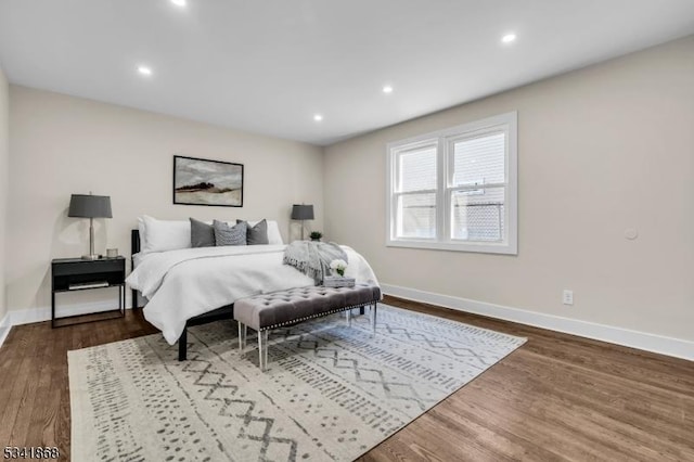 bedroom with recessed lighting, wood finished floors, and baseboards