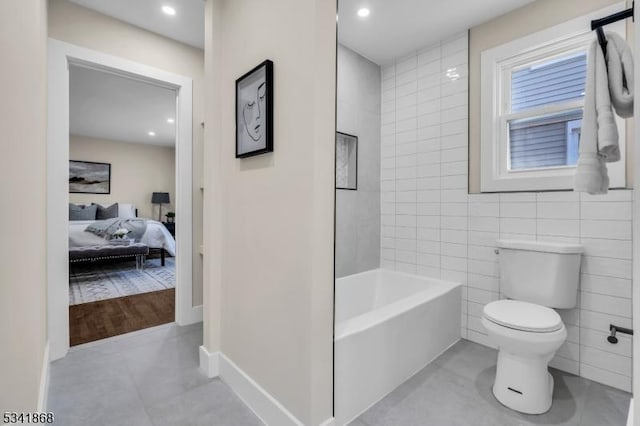 bathroom featuring a tub to relax in, tile walls, toilet, connected bathroom, and tile patterned floors