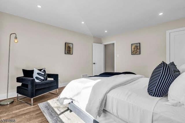 bedroom featuring baseboards, wood finished floors, visible vents, and recessed lighting