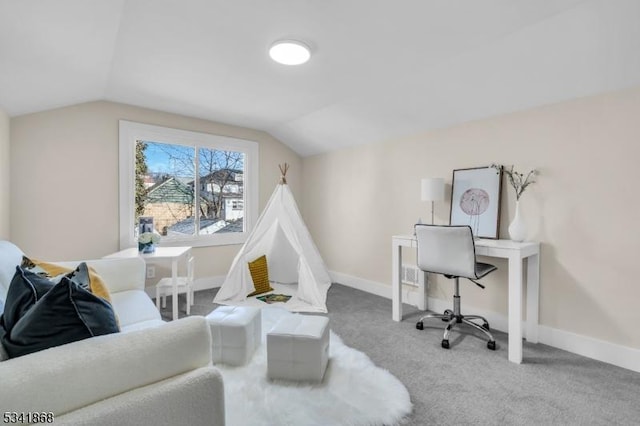 carpeted office space featuring vaulted ceiling and baseboards