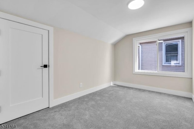 bonus room featuring lofted ceiling, carpet, and baseboards