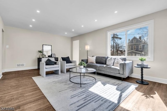 living room featuring recessed lighting, wood finished floors, visible vents, and baseboards