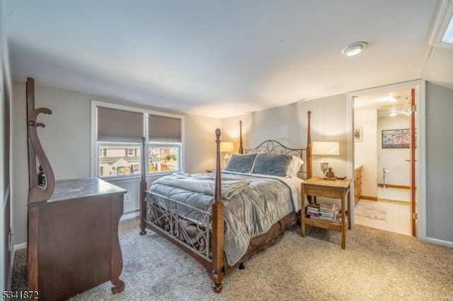 carpeted bedroom featuring connected bathroom and baseboards