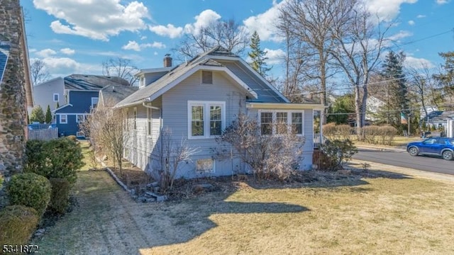 view of side of home with a yard and a chimney