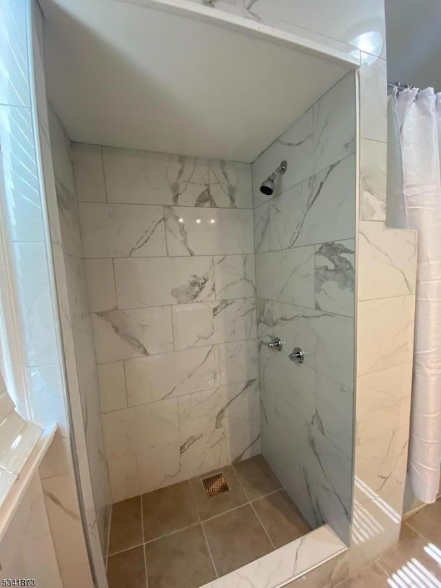 full bath with tile patterned flooring and tiled shower