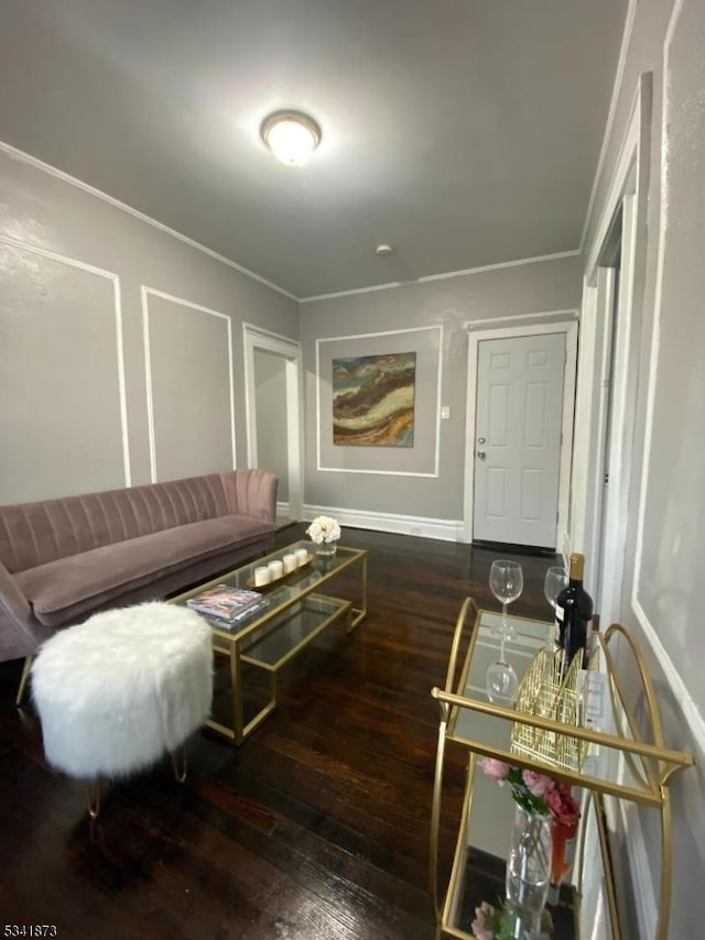 living room with wood-type flooring, crown molding, and baseboards