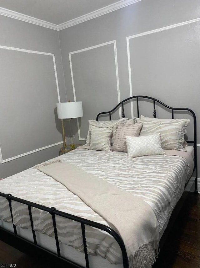 bedroom featuring crown molding and wood finished floors