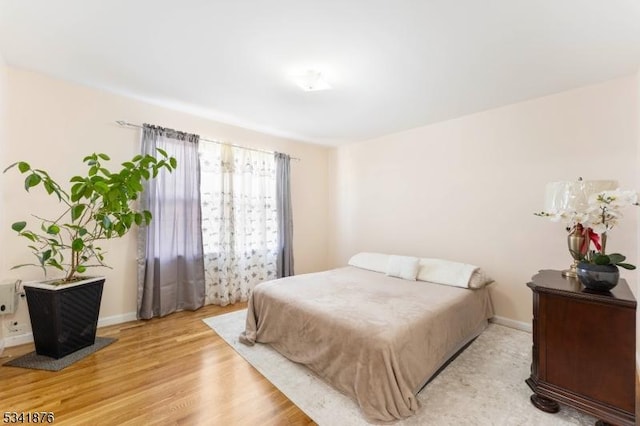 bedroom featuring light wood-type flooring and baseboards