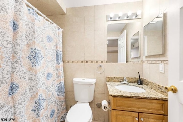 bathroom featuring toilet, a shower with shower curtain, vanity, tile walls, and decorative backsplash