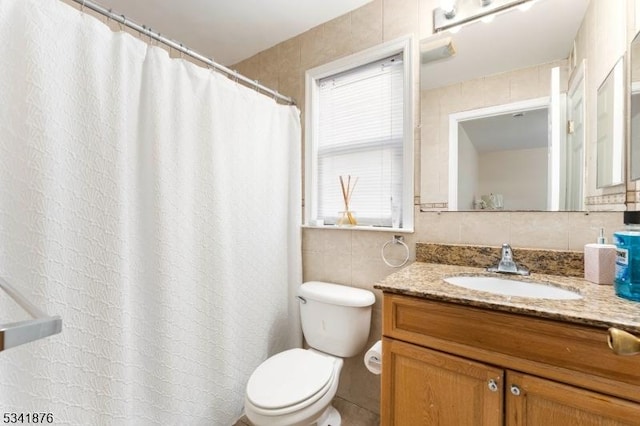 bathroom featuring a shower with curtain, toilet, tile walls, and vanity