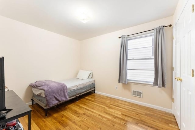 bedroom featuring light wood finished floors, baseboards, and visible vents