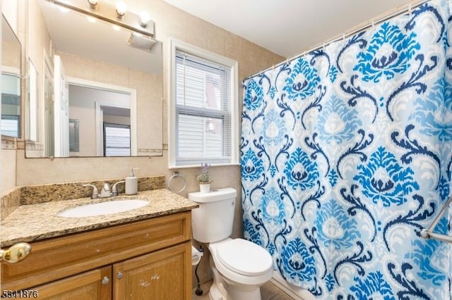 bathroom with curtained shower, vanity, and toilet