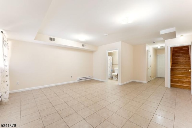 spare room with a baseboard radiator, visible vents, stairway, light tile patterned flooring, and baseboards