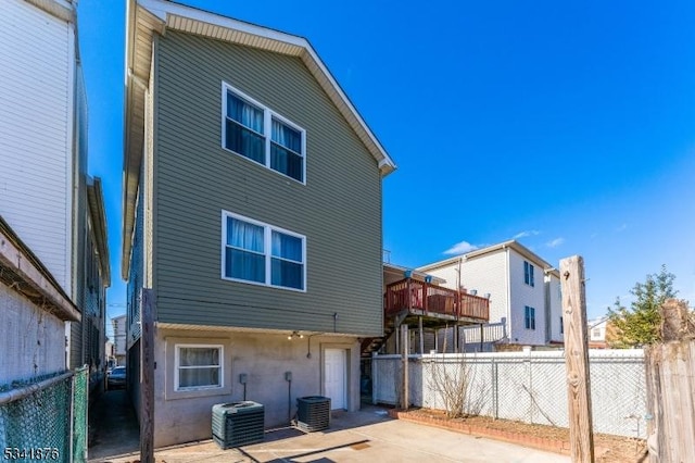 back of property with central AC, a patio, and a fenced backyard