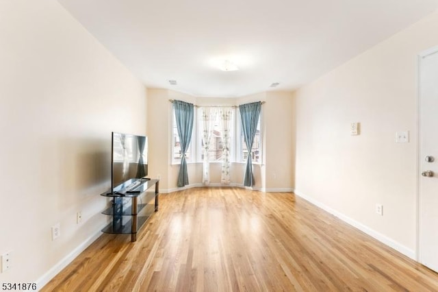 unfurnished living room featuring light wood-style flooring and baseboards