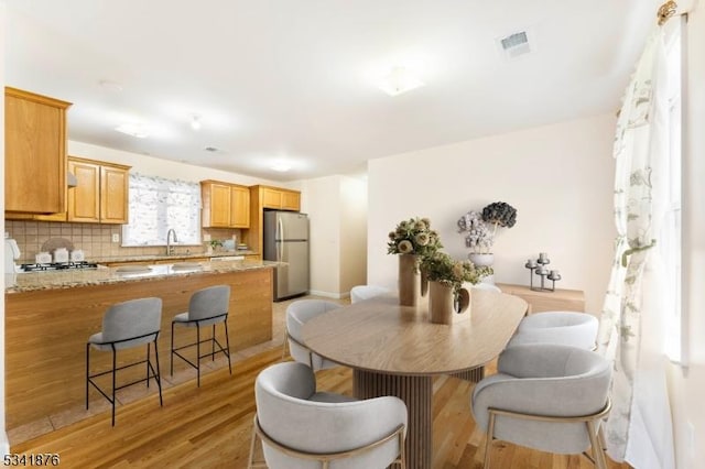 dining space featuring light wood-type flooring and visible vents