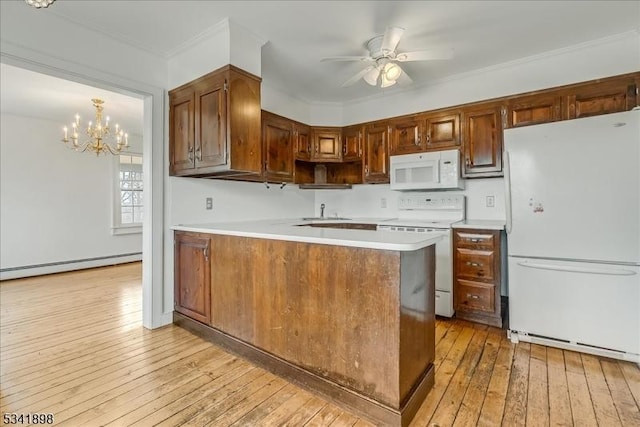 kitchen featuring white appliances, light countertops, light wood-style flooring, and a peninsula