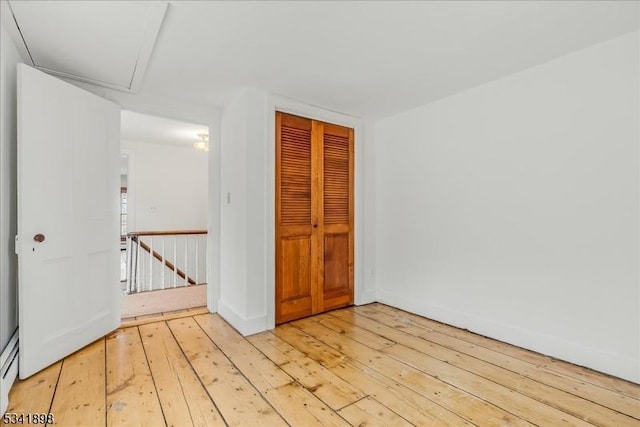 spare room featuring light wood-style flooring and baseboard heating