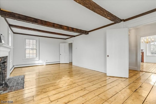 unfurnished living room featuring light wood-type flooring, a fireplace, an inviting chandelier, and a healthy amount of sunlight