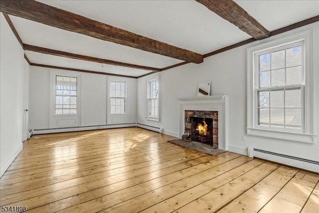 unfurnished living room with light wood-style floors, a brick fireplace, and a baseboard heating unit