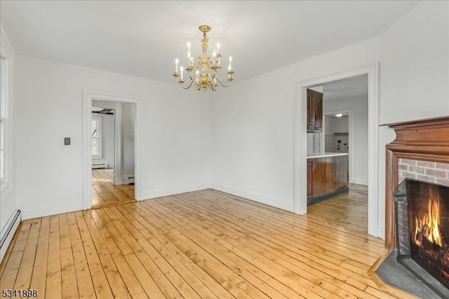 interior space with a brick fireplace, a baseboard radiator, baseboards, and light wood-style floors