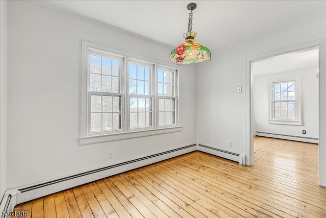 empty room with light wood-type flooring, a baseboard heating unit, and baseboard heating