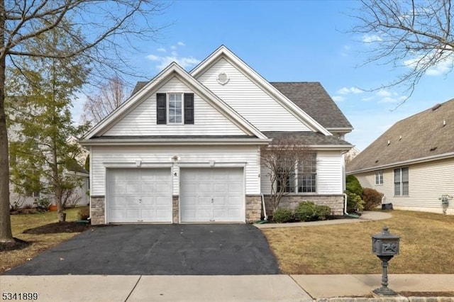 view of front of house featuring a front lawn, a garage, stone siding, and driveway