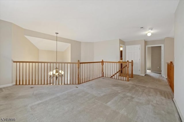 unfurnished room with carpet flooring, visible vents, baseboards, and a chandelier