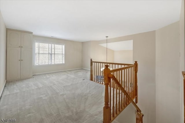 unfurnished room featuring baseboards and light carpet