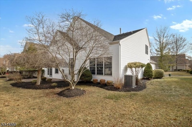 view of home's exterior with central AC unit and a lawn