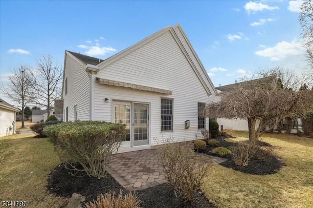 rear view of property with a patio and a lawn