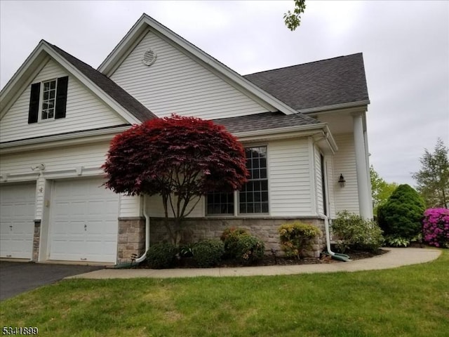 view of front of house with aphalt driveway, stone siding, and a shingled roof