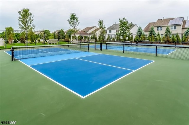 view of sport court featuring a residential view and fence