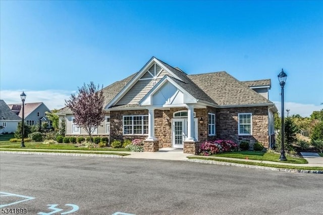 craftsman house with stone siding and roof with shingles