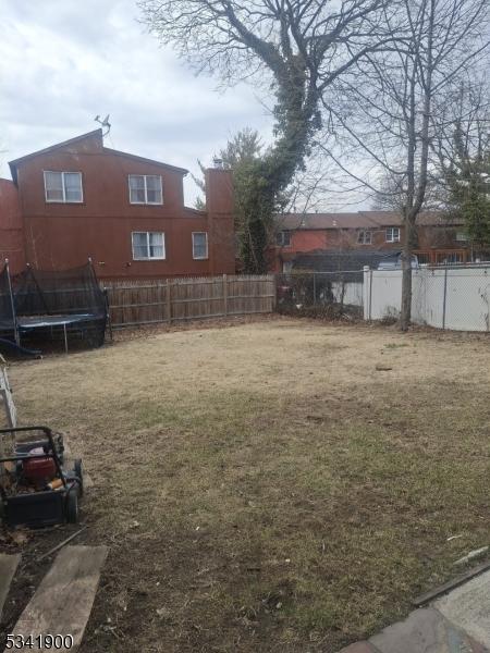 view of yard with a trampoline and fence