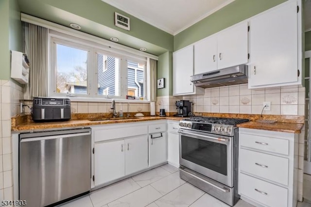 kitchen featuring white cabinets, appliances with stainless steel finishes, marble finish floor, under cabinet range hood, and a sink