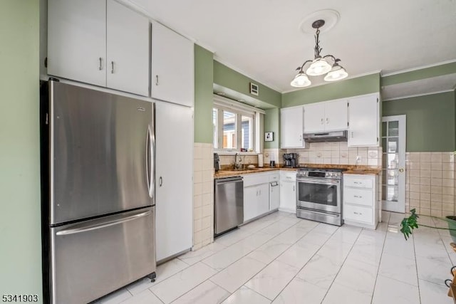 kitchen with marble finish floor, appliances with stainless steel finishes, white cabinetry, a sink, and under cabinet range hood