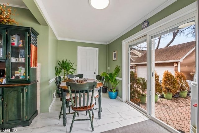 dining area with ornamental molding and baseboards