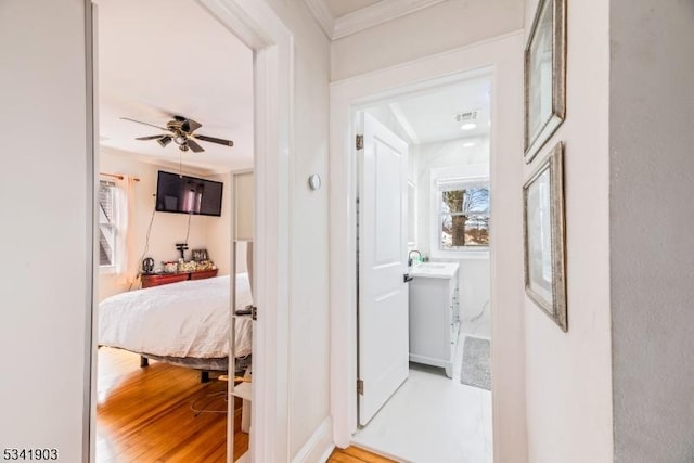 corridor featuring a sink and wood finished floors