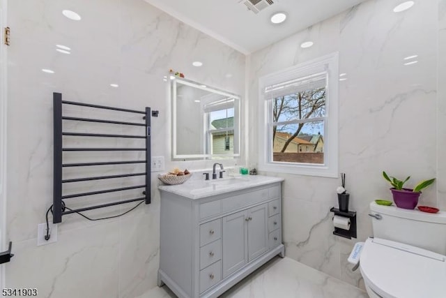 bathroom featuring marble finish floor, visible vents, toilet, radiator heating unit, and vanity