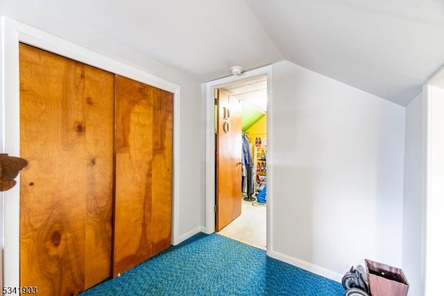 corridor with vaulted ceiling, carpet flooring, and baseboards