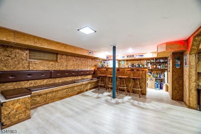 bar with a dry bar and wood finished floors