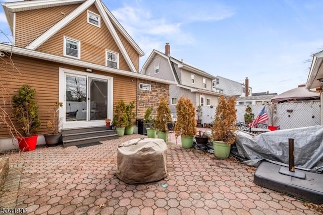 rear view of property with entry steps and a patio