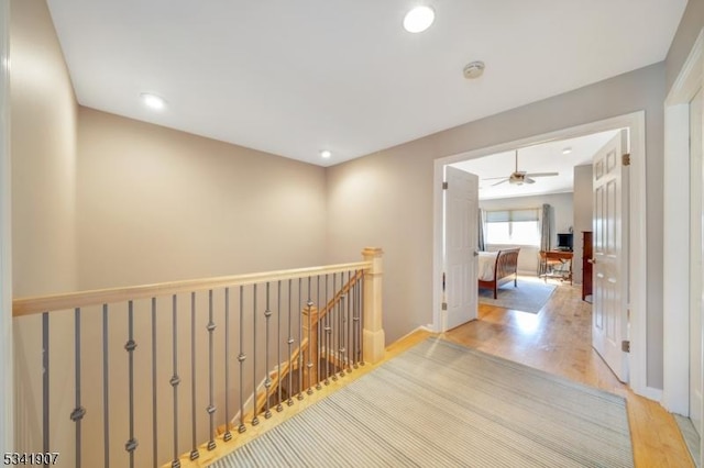 hallway featuring recessed lighting, baseboards, an upstairs landing, and wood finished floors