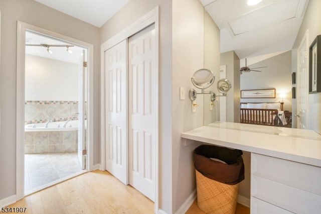 full bathroom with a garden tub, wood finished floors, and baseboards