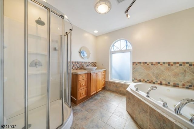 bathroom featuring a bath, a stall shower, vanity, and tile patterned floors