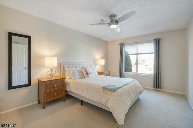 bedroom featuring light carpet, visible vents, baseboards, and a textured ceiling