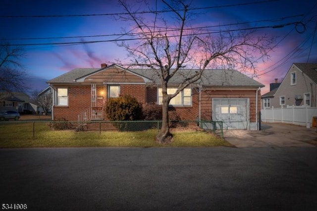 view of front of house featuring an attached garage, driveway, a fenced front yard, and brick siding