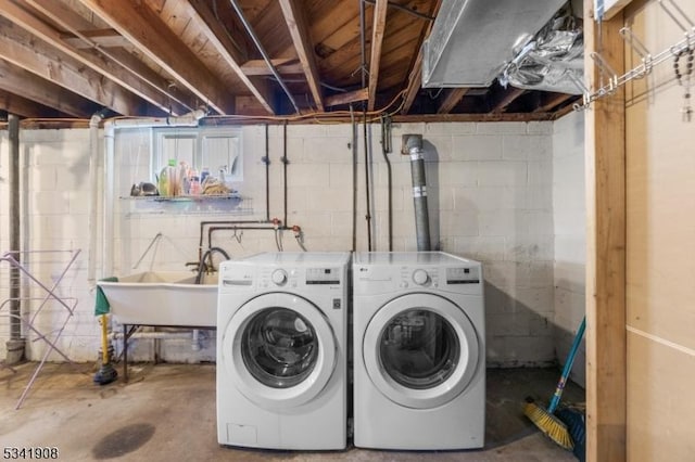 clothes washing area with laundry area, washing machine and dryer, and a sink