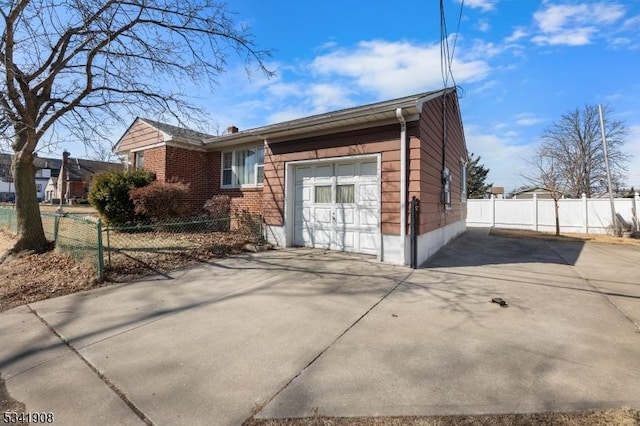 view of front of house featuring an attached garage, fence, concrete driveway, and brick siding